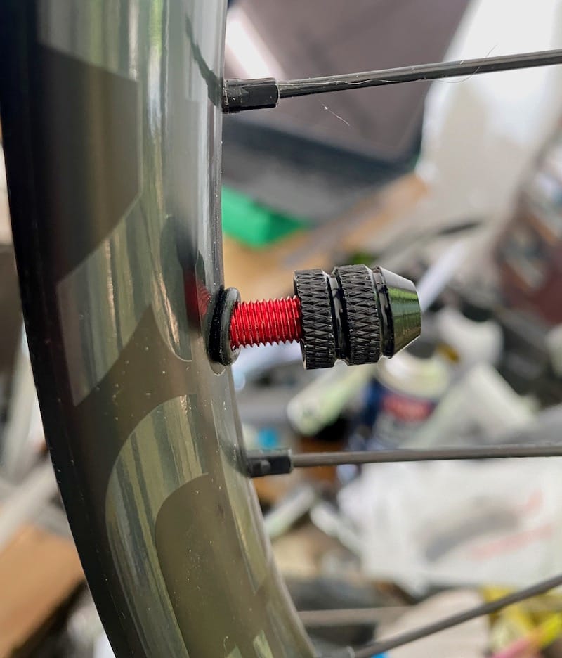 Tubeless valve being installed, note the o=ring sits between valve nut and rim